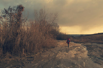 Man walking on land against sky