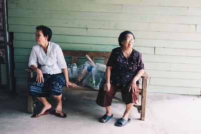 Portrait of smiling young woman sitting on bench