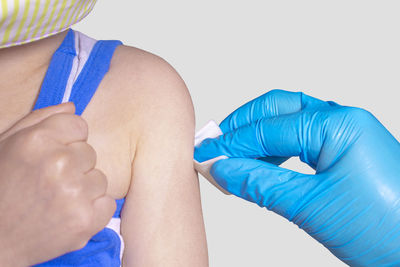 Close-up of hands holding blue over white background