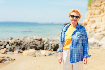 Elderly woman walking on the beach near the sea