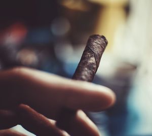 Close-up of hand holding cigarette