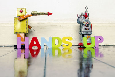 Close-up of toys on table against wall