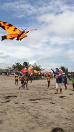 People on beach against sky