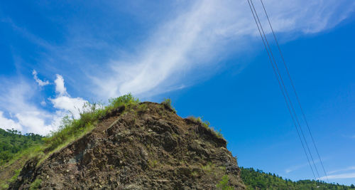 Low angle view of mountain against blue sky