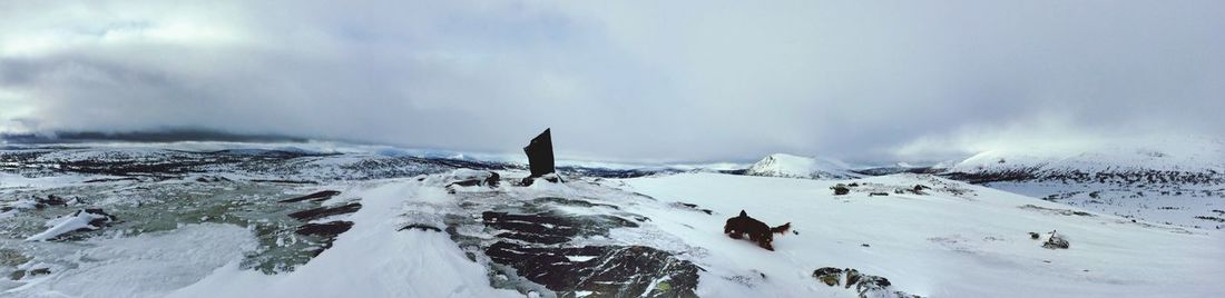 Panoramic view of snow covered landscape against sky