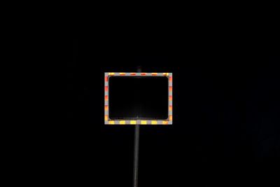 Close-up of basketball hoop against black background