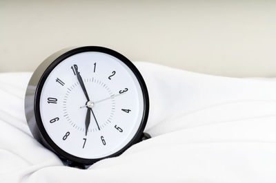 Close-up of clock on bed