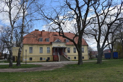 Houses and trees on field against sky