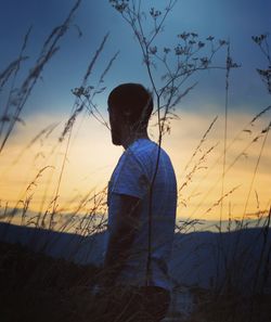 Rear view of silhouette man looking at sunset