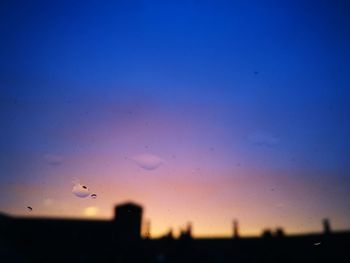 Silhouette birds flying against sky during sunset