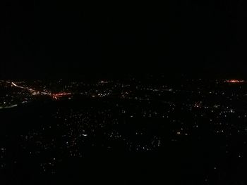 Illuminated city against sky at night