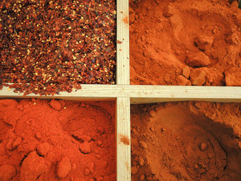 Directly above shot of red chili powders in containers at market stall