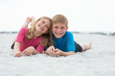 Portrait of smiling boy and woman at sea shore