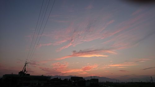 Silhouette electricity pylon against sky during sunset