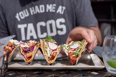 Closeup of man eating tacos outside in summer