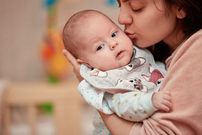 Mother embracing baby at home