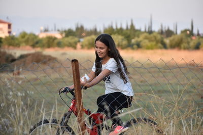 Side view of young woman standing on field