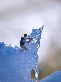 Man skiing on rock in snow