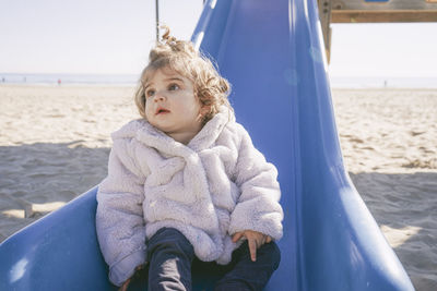 Cute baby girl sitting on slide