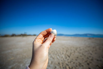 Close-up of human hand on sand