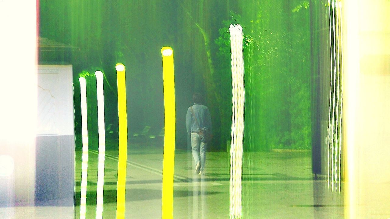 REFLECTION OF MAN IN ILLUMINATED WATER