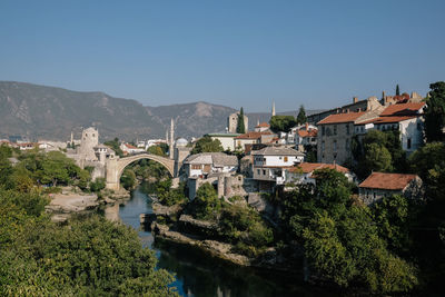 River amidst buildings in town against clear sky