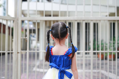 Rear view of woman standing against wall