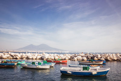 Boats moored in sea against sky