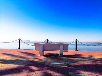 Scenic view of beach against clear blue sky