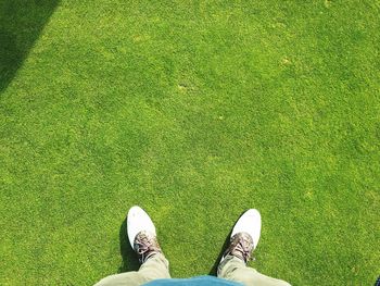 Low section of man standing on grass