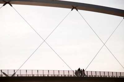 Low angle view of family on hoge brug bridge against clear sky
