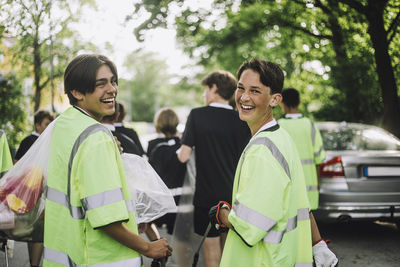 Portrait of happy boys wearing reflective clothing walking together