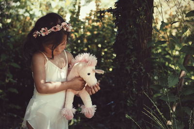 Cute girl holding puppy in park