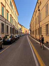 Cars on road by buildings in city