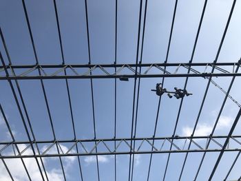 Low angle view of power lines against clear blue sky