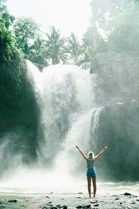 Full length of woman standing in water against sky