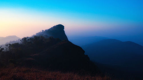 Scenic view of mountains against clear sky at sunset