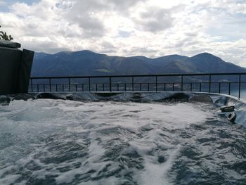 Scenic view of sea and mountains against sky