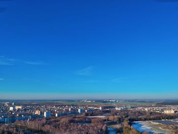 High angle view of buildings in city against blue sky