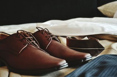 Close-up of shoes on bed