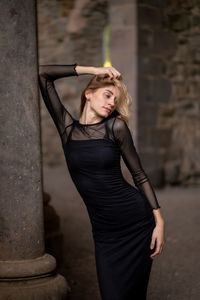 Young woman standing against wall