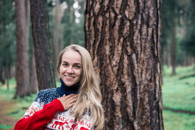 Portrait of woman smiling while standing in forest