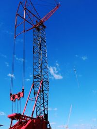 Low angle view of amusement park against blue sky