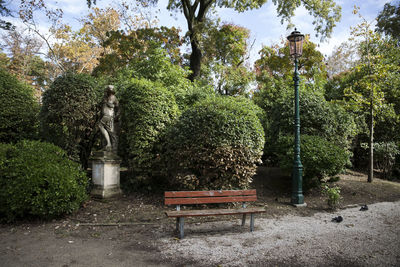 Statue amidst trees in park against sky