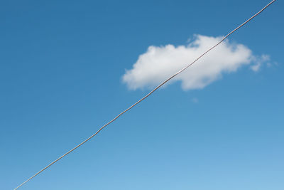 Low angle view of cable against blue sky during sunny day
