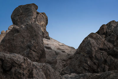 Low angle view of rock formation against clear sky