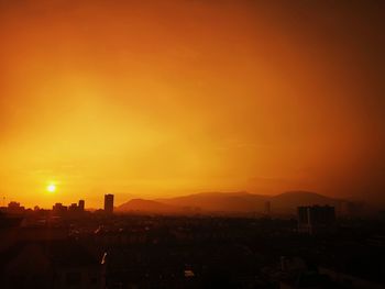 Silhouette buildings against sky during sunset