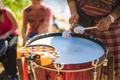 Midsection of drummer playing during festival