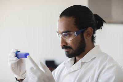 Young man scientist with lab coat checking a sample