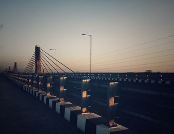 Suspension bridge against sky during sunset